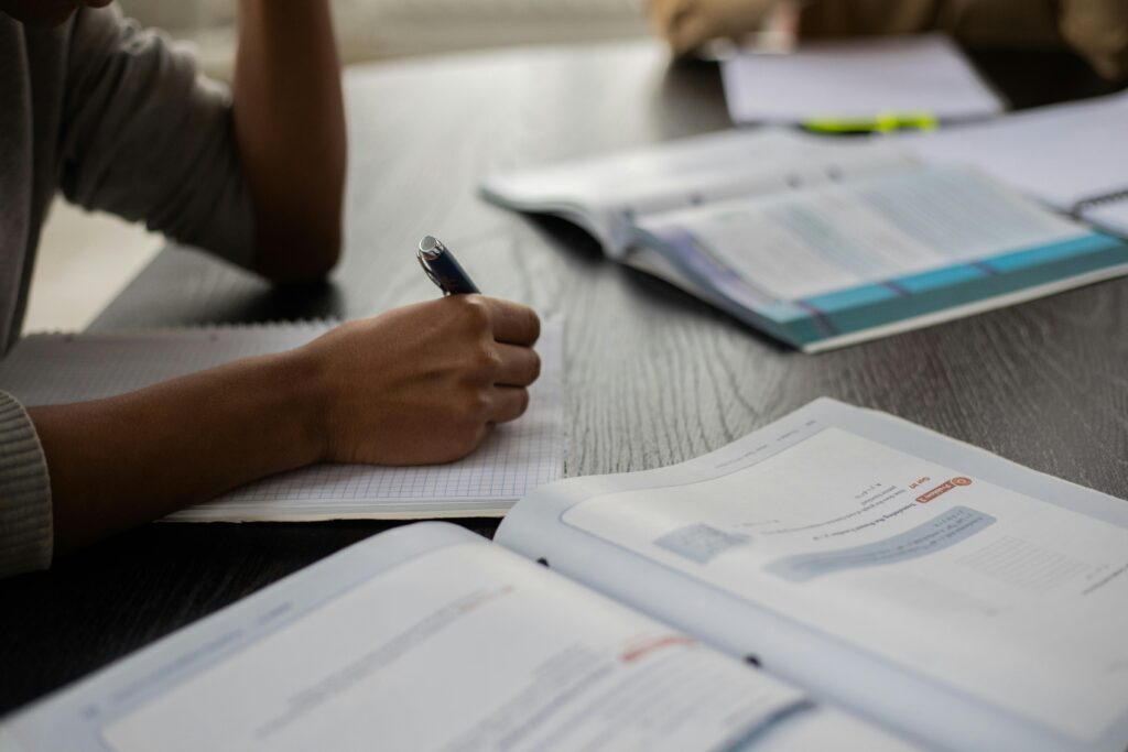 Photo by Monstera Production: https://www.pexels.com/photo/crop-black-person-writing-in-workbook-while-studying-6238011/